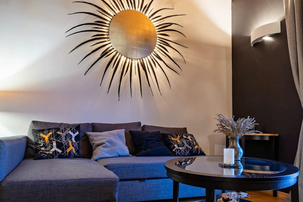 Tiny living room with sofa, coffee table, and wall decor in form of sun